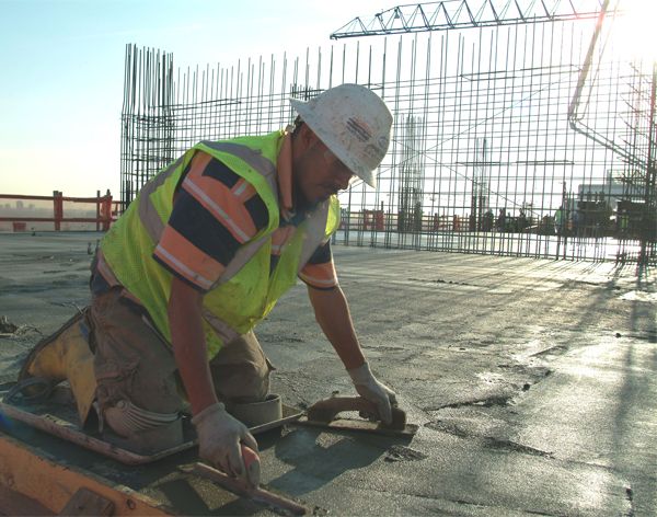 Работник проводит затирание бетонного покрытия
